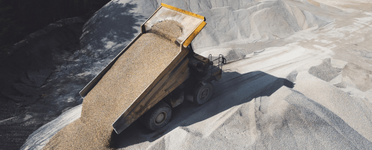 Dump truck unloading construction aggregate.